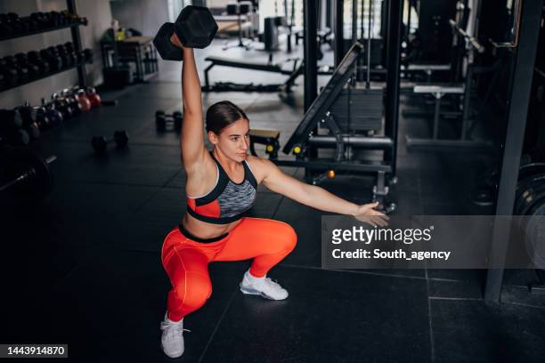 allenamento donna in forma con manubrio - sollevamento pesi femminile foto e immagini stock