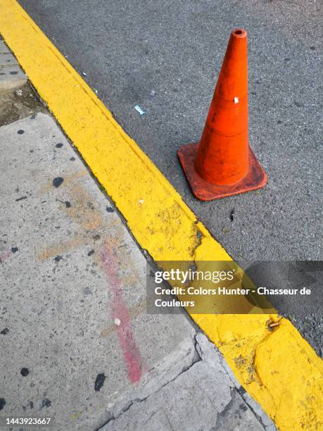 a red cone on the asphalt of a street and next to a sidewalk in manhattan - hunter, new york stock-fotos und bilder