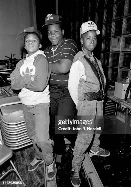 Three young boys wearing Adidas hats pose for a portrait, Taunton, Massachusetts, March 1985.