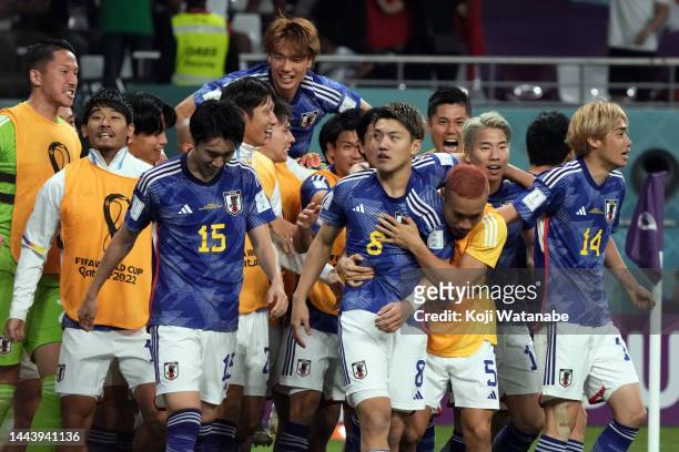 Ritsu Doan of Japan celebrates with teammates after scoring their team's first goal during the FIFA World Cup Qatar 2022 Group E match between...