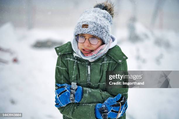 portrait of a teenage boy who is very cold during the blizzard on a winter day - beef stockfoto's en -beelden