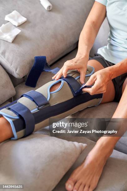 woman healing her leg at home after knee surgery - nylon fastening tape stock pictures, royalty-free photos & images