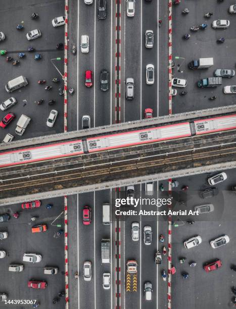 chaotic scene showing traffic at a road intersection photographed from a drone point of view, hanoi, vietnam - railway bridge stock-fotos und bilder