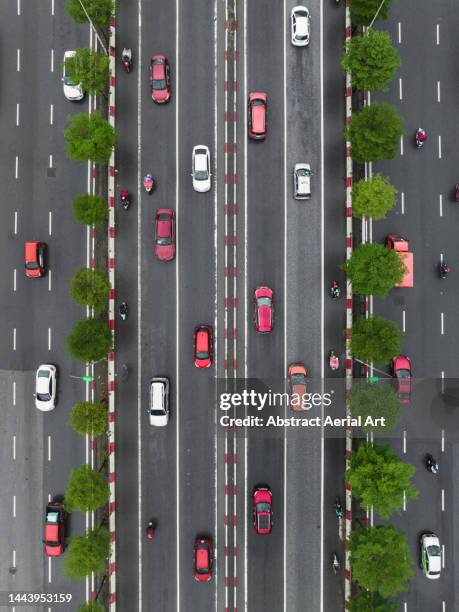 aerial shot directly above vehicles driving on a treelined highway, hanoi, vietnam - cars on motor way stockfoto's en -beelden