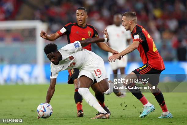 Alphonso Davies of Canada controls the ball against Youri Tielemans and Timothy Castagne of Belgium during the FIFA World Cup Qatar 2022 Group F...