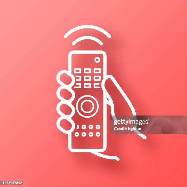 hand with remote control. icon on red background with shadow - hand tv controller stock illustrations