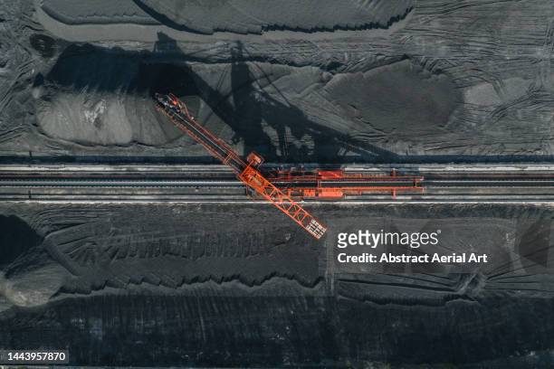 aerial image directly above an industrial machine working in a coal pit, vietnam - naturvorkommen stock-fotos und bilder