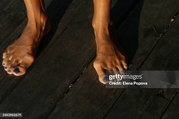 barefoot woman with bunions standing on wooden floor, top view - hallux valgus foto e immagini stock