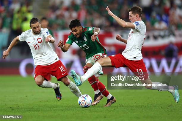 Alexis Vega of Mexico battles for the ball with Grzegorz Krychowiak and Jakub Kaminski of Poland during the FIFA World Cup Qatar 2022 Group C match...