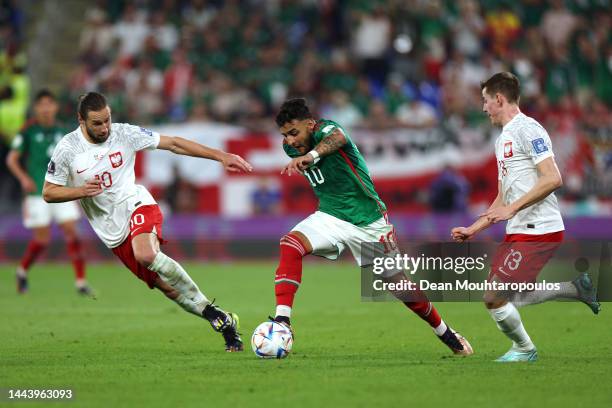 Alexis Vega of Mexico battles for the ball with Grzegorz Krychowiak and Jakub Kaminski of Poland during the FIFA World Cup Qatar 2022 Group C match...