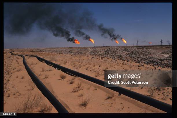 Flames indicate gas burn off as pipelines carry oil June 15, 1997 in Hassi Messaoud, Algeria. The recent completion of a multi-billion dollar oil...