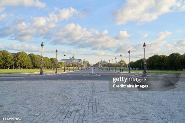 av. du maréchal gallieni crossing the esplanade of the invalids up to the alexandre iii bridge, view from a front angle without people and public lighting poles in a row. - avenue photos et images de collection