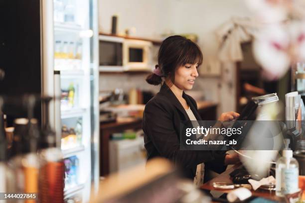owner checking takeaway order from touch screen on counter bar. - new zealand small business stock pictures, royalty-free photos & images