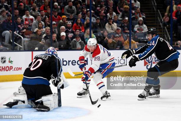 Christian Dvorak of the Montreal Canadiens attempts a shot on goal against Joonas Korpisalo and Erik Gudbranson of the Columbus Blue Jackets during...