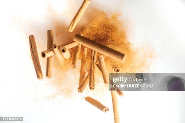 food explosion with cinnamon sticks and powder - cinnamon stock pictures, royalty-free photos & images