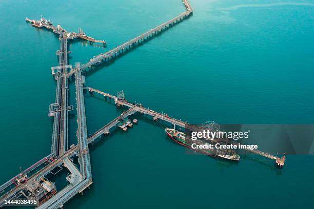 aerial view oil ship tanker load or unload oil at loading dock from refinery, energy or oil industry concept. - oil tanker ships stock pictures, royalty-free photos & images