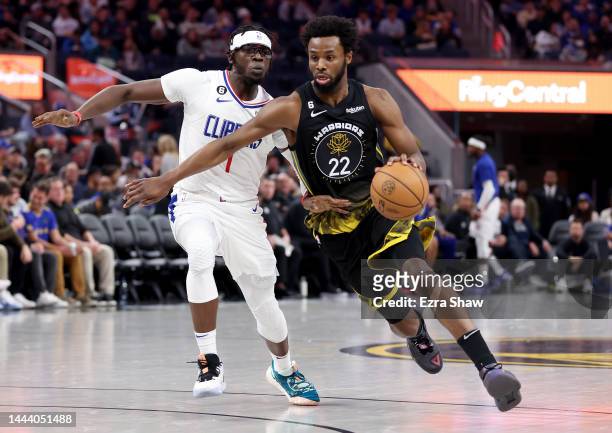 Andrew Wiggins of the Golden State Warriors is guarded by Reggie Jackson of the LA Clippers at Chase Center on November 23, 2022 in San Francisco,...