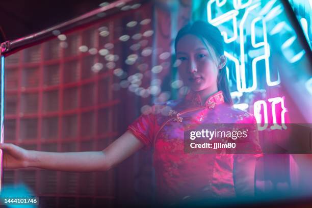 Studio portrait photo of a beautiful young asian female lady model wearing elegant red traditional chinese dress cheongsam costume with cool emotion look standing beside a tuk tuk taxi vehicle studio portrait photo beautiful young asian