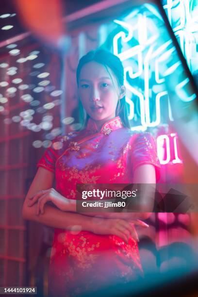 Studio portrait photo of a beautiful young asian female lady model wearing elegant red traditional chinese dress cheongsam costume with cool emotion look standing beside a tuk tuk taxi vehicle studio portrait photo beautiful young asian