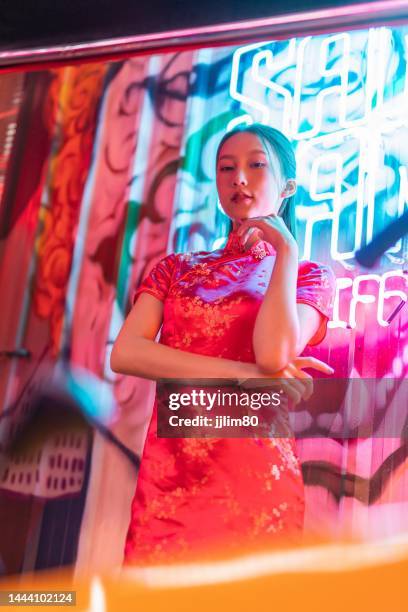 Studio portrait photo of a beautiful young asian female lady model wearing elegant red traditional chinese dress cheongsam costume with cool emotion look standing beside a tuk tuk taxi vehicle studio portrait photo beautiful young asian