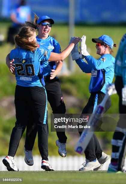 Darcie Brown of the Adelaide Strikers celebrates the wicket of Danielle Wyatt of the Brisbane Heat with Maddie Penna of the Adelaide Strikers and...