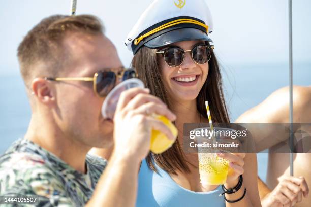 friends drinking juice on boat - chapéu de marinheiro imagens e fotografias de stock