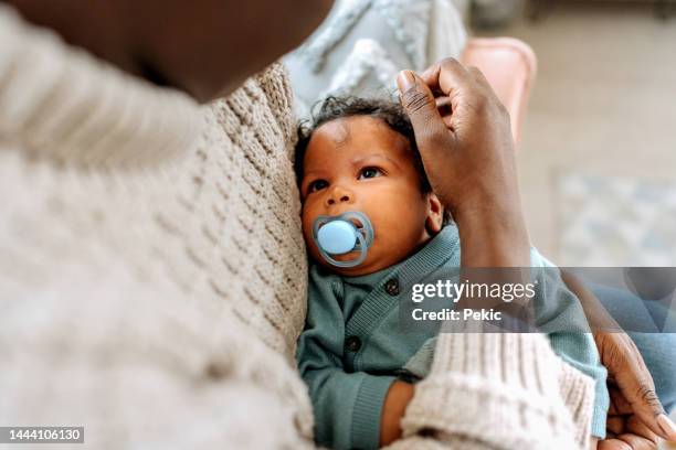 tired little baby boy in his mother's arms - lullaby stock pictures, royalty-free photos & images