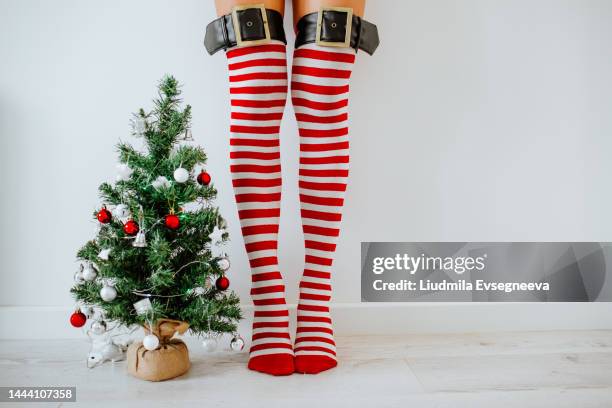 long woman's legs in christmas socks against white wall. - long skinny legs foto e immagini stock