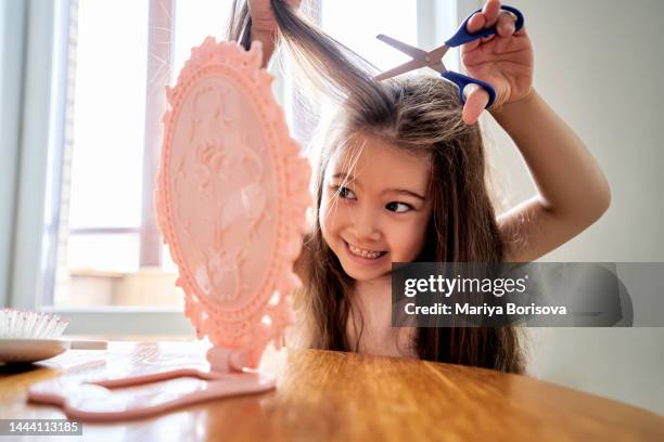 a girl about 6 years old cuts off her hair. - kids misbehaving stock pictures, royalty-free photos & images
