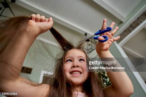 a girl about 6 years old cuts off her hair. - 6 7 years stock-fotos und bilder