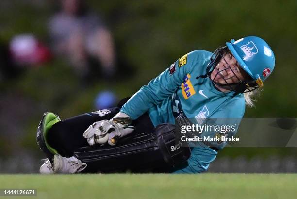 Georgia Redmayne of the Brisbane Heat goes down in pain after catching Deandra Dottin of the Adelaide Strikers during the Women's Big Bash League...