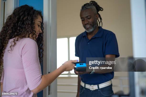 woman receiving an online shopping order - compras online stock pictures, royalty-free photos & images