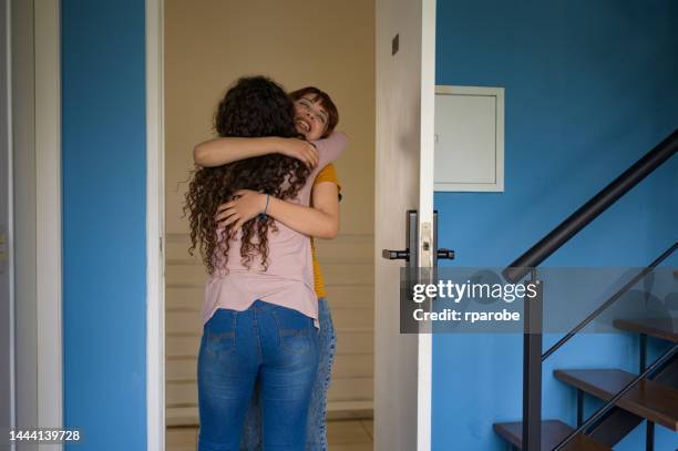 woman welcoming her friend home - compras online stock pictures, royalty-free photos & images