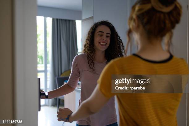 woman welcoming her friend home - recebendo 個照片及圖片檔