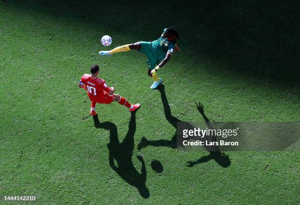 Andre-Frank Zambo Anguissa of Cameroon clears the ball against Granit Xhaka of Switzerland during the FIFA World Cup Qatar 2022 Group G match between...