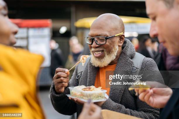 sonriente londinense disfrutando de comida al aire libre - borough market fotografías e imágenes de stock