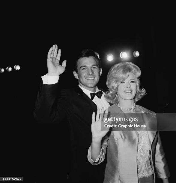 American actor James Stacy and his wife, American actress and singer Connie Stevens, waving as they attend the 36th Academy Awards ceremony, held at...