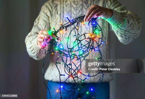 untangling christmas fairy lights - tangled christmas lights stock-fotos und bilder