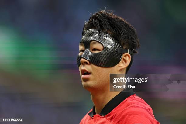 Heungmin Son of Korea Republic looks on while wearing a face mask wearing a face mask during the FIFA World Cup Qatar 2022 Group H match between...