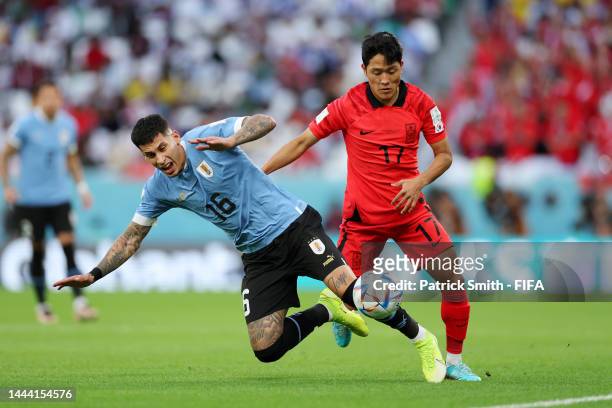 Mathias Olivera of Uruguay battles for possession with Sangho Na of Korea Republic during the FIFA World Cup Qatar 2022 Group H match between Uruguay...
