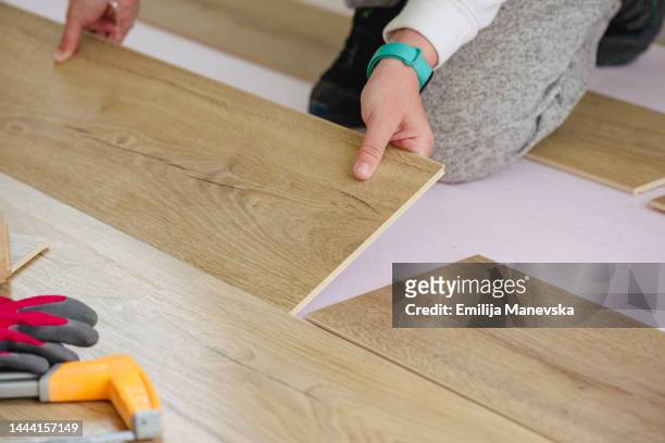 close up of woman installing laminate flooring - wood laminate flooring fotografías e imágenes de stock