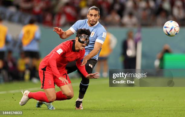 Heungmin Son of Korea Republic is challenged by Martin Caceres of Uruguay during the FIFA World Cup Qatar 2022 Group H match between Uruguay and...