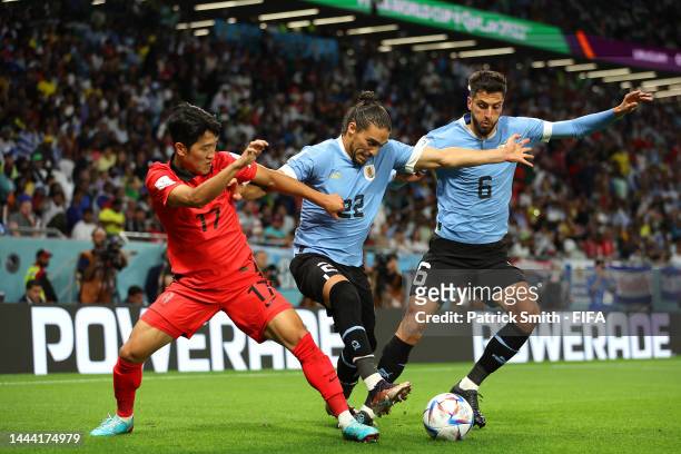Sangho Na of Korea Republic battles for possession with Martin Caceres and Rodrigo Bentancur of Uruguay during the FIFA World Cup Qatar 2022 Group H...