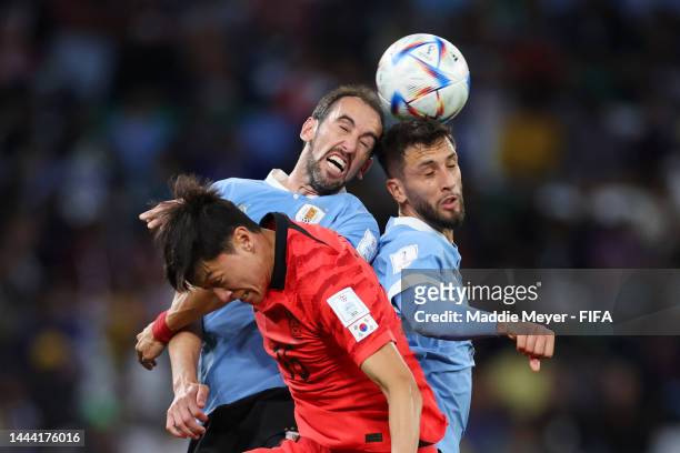 Uijo Hwang of Korea Republic competes for a header against Diego Godin and Rodrigo Bentancur of Uruguay during the FIFA World Cup Qatar 2022 Group H...