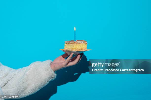 woman's hand holding birthday cake - geburtstagstorte stock-fotos und bilder