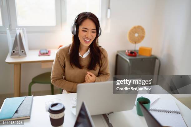 young asian ethnicity businesswoman having a video conference at her office - online meeting stock pictures, royalty-free photos & images