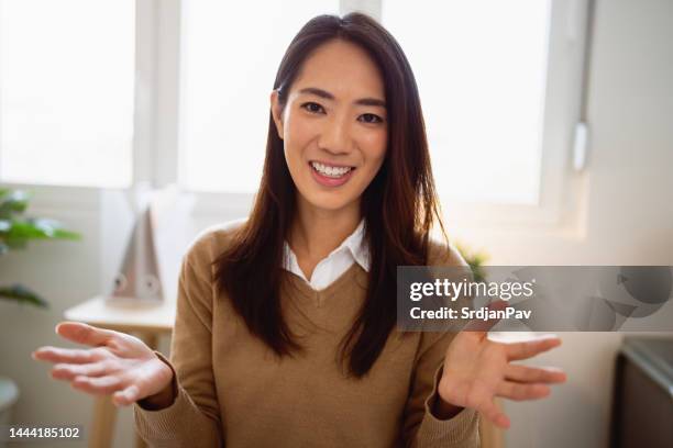 ritratto di giovane donna d'affari di etnia asiatica mentre ha una videoconferenza nel suo ufficio - webcam foto e immagini stock
