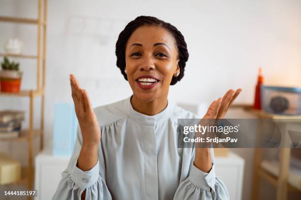 ritratto di donna d'affari afroamericana sorridente mentre ha una videoconferenza nel suo ufficio - explain foto e immagini stock