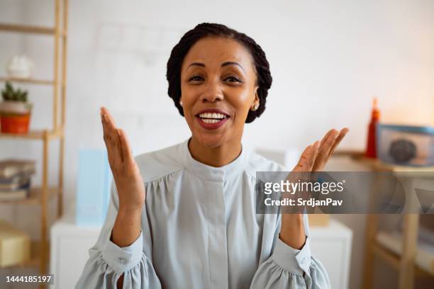 portrait of smiling african-american businesswoman while having a video conference at her office - one person talking stock pictures, royalty-free photos & images