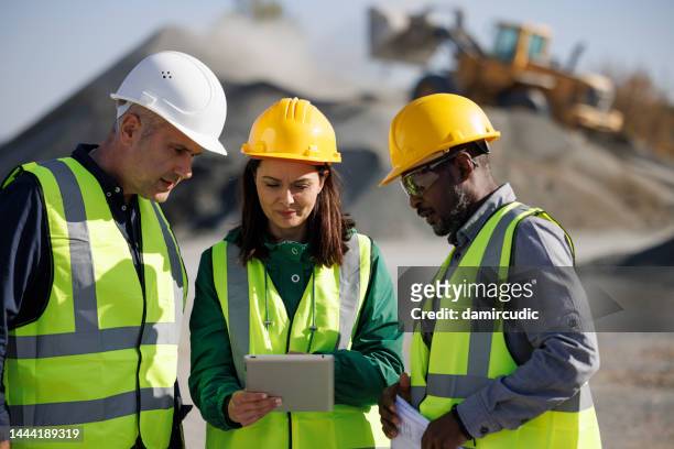 engineers discussing at building site - construction planning stockfoto's en -beelden